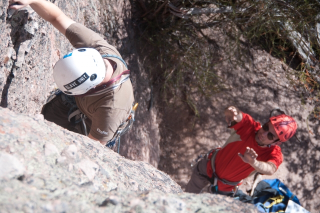  Hombre escalando con la ayuda del instructor 