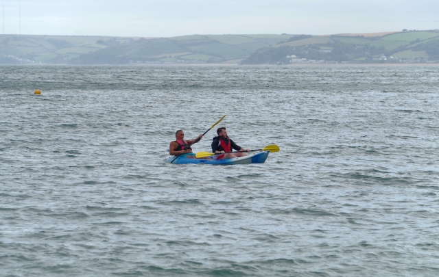  Hombres con ayudas de flotabilidad rojas y navegando en canoa por el río 