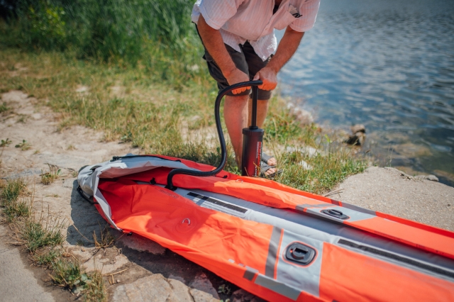  Hombre inflando un kayak rojo 