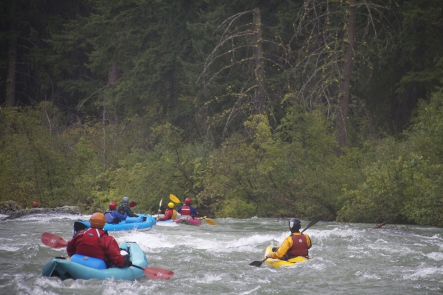  Cuatro personas en kayaks inflables azules y amarillos 