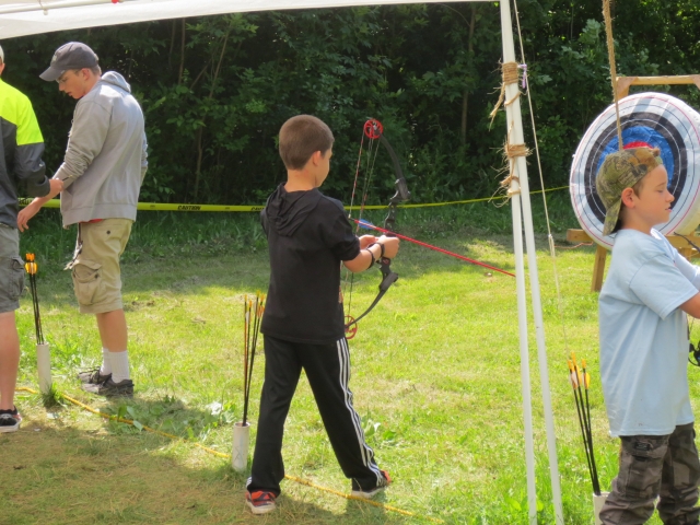  Dos niños con playera negra y azul -camisas preparándose para el jalo con arco