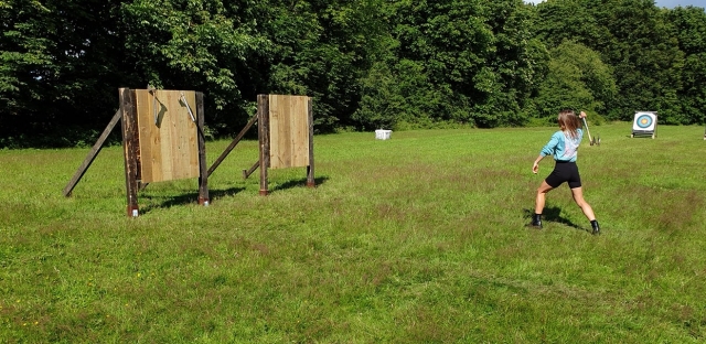  Niña con playera azul aventando hacha 