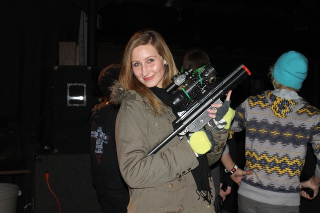  Niña sonriendo, vistiendo una chamarra marrón y preparándose para su sesión de laser tag