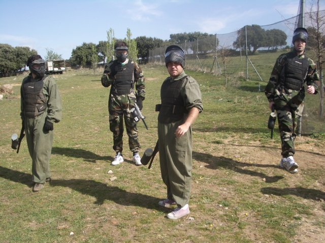  Cuatro hombres preparándose y vistiendo trajes de camuflaje para jugar gotcha 