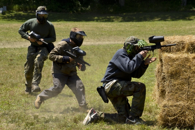 Grupo vistiendo trajes de camuflaje jugando gotcha 