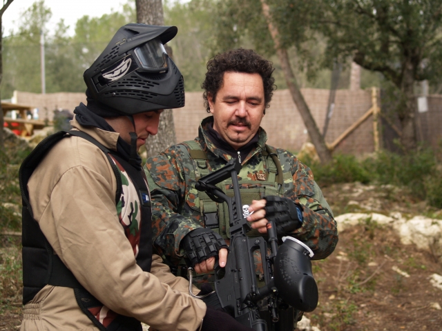  Dos amigos con traje de camuflaje y máscaras negras preparándose para jugar gotcha 