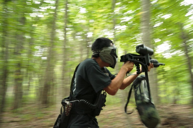  Niño con playera verde jugando paintball