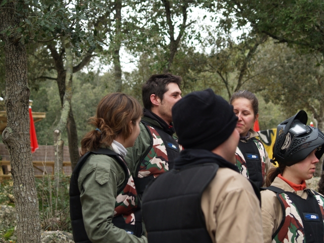  Grupo de hombres y mujes preparándose y vistiendo trajes verdes antes de jugar gotcha 