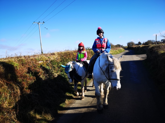  Niña y mujer subiendo caballos blancos y divirtiéndose