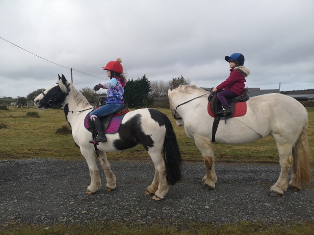  Dos niñas subiendo a caballo y a punto de divertirse 