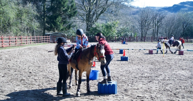  Niño con chamarra azul y casco negro preparándose para iniciar la cabalgamarra 