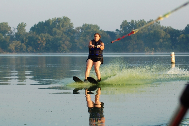 Mujer con traje de baño negro haciendo esquí acuático
