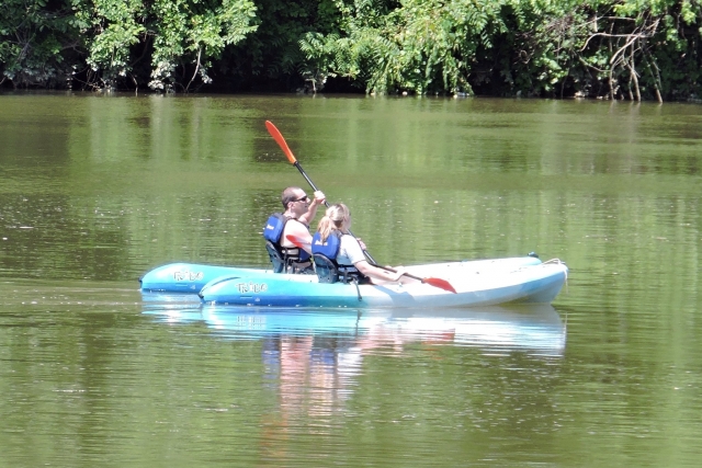 Dos personas divirtiéndose divirtiéndose haciendo kayak en un kayak azul