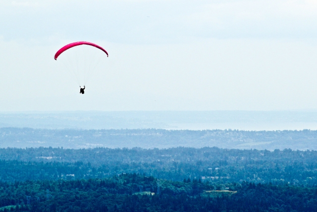 Persona en un parapenle volador rojo 