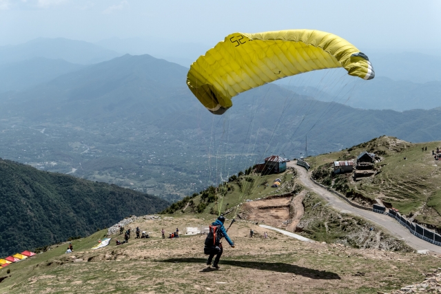  Hombre con suéter azul preparándose para volar en parapenle volador amarillo 