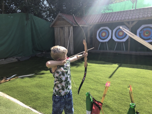 Niño con playera duranle su sesión de jalo con arco bajo el sol