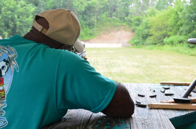  Hombre con gorra beige y playera azul duranle su sesión de rifle 