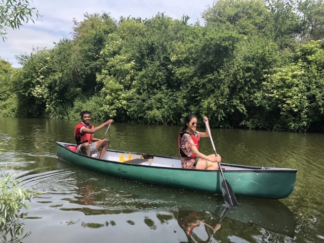 Niño y niña con ayudas de flotabilidad rojas haciendo piragüismo en el río Blue 