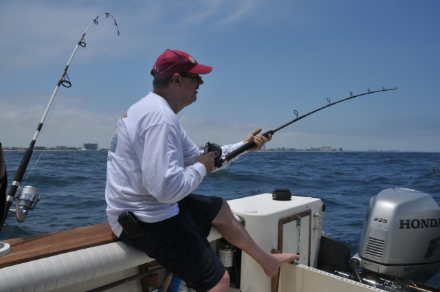  Hombre con suéter blanco y gorra roja pescando 