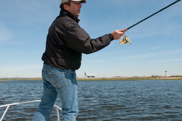  Hombre con chamarra negra y gorra pescando 