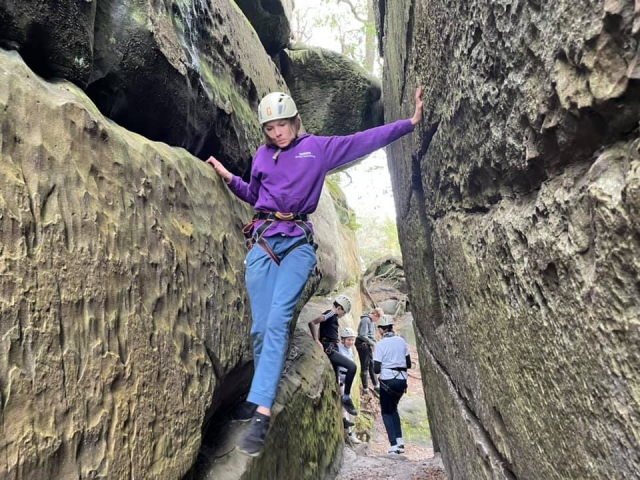  Niña con suéter morado y casco blanco duranle su sesión de escalada de fin de semana 