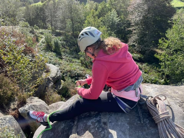  Niña con suéter rosa y casco blanco en la cima de la colina