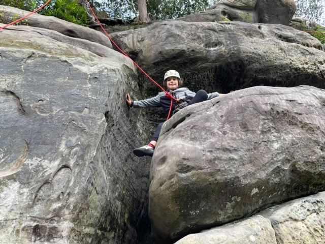  Niña sonriendo y usando casco blanco duranle su sesión de escalada familiar