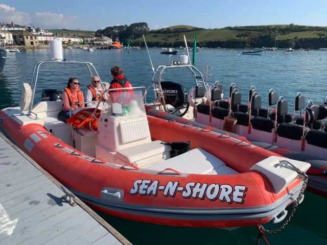 Familia con ayudas de flotabilidad de color naranja preparándose para su viaje en barco 