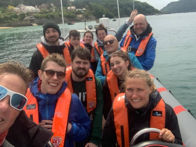  Amigos con ayudas de flotabilidad de color naranja y lentes de sol duranle su viaje en barco 