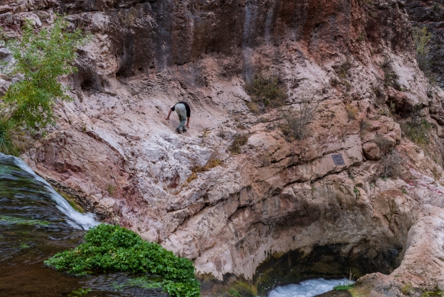 Hombre caminando por un desfiladero y agua en el fondo 