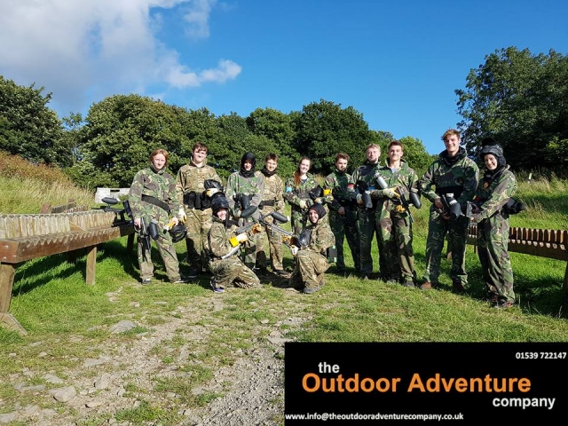  Equipo de personas con trajes de camuflaje preparándose para el gotcha 
