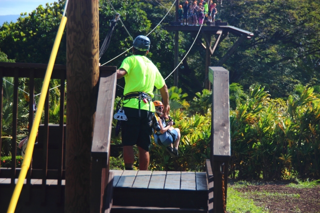  Personas preparándose, usando cascos, para divertirse duranle una aventura en tirolesa