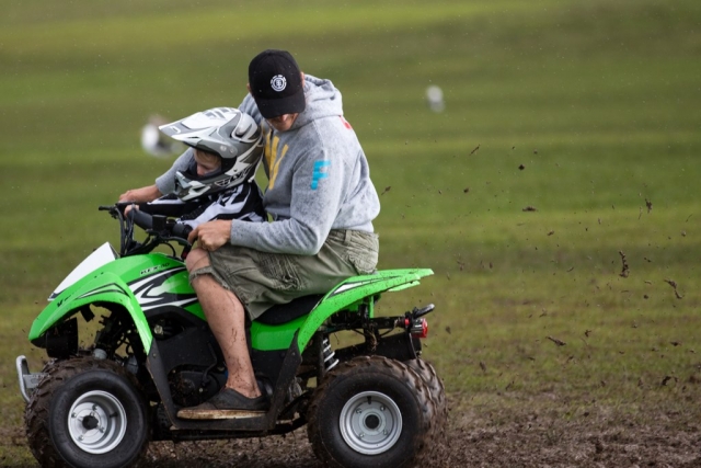  Un niño con casco disfrutando de su sesión de cuatrimoto y subiendo con el instructor 