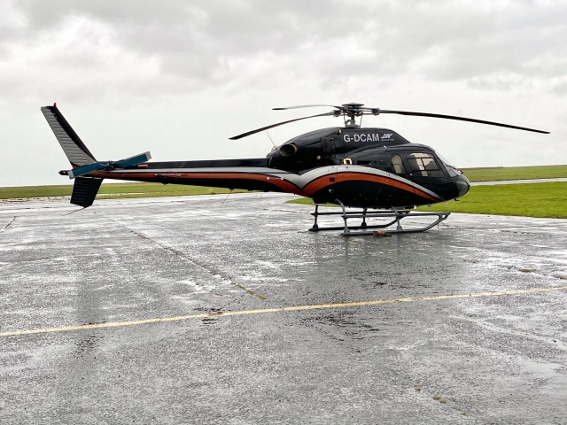  Helicóptero negro, rojo y blanco a punto de despegar para volar sobre Kent 