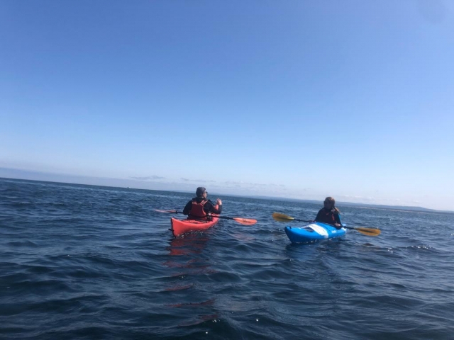  Niño con ayudas de flotabilidad rojas y niña con ayudas de flotabilidad azules en kayak 