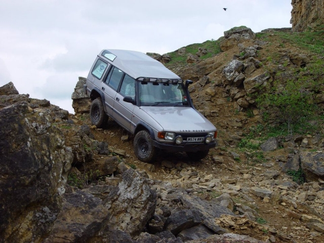  Land Rover 4x4 gris bajando por una zona rocosa 