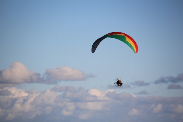  Persona volando con paramotor verde, amarillo y rojo 