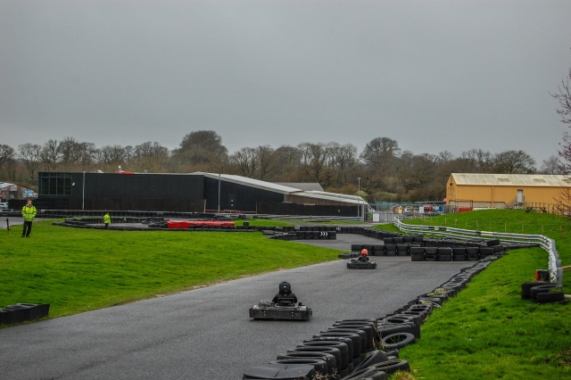  Conductores con cascos rojos y negros y trajes de conducción negros karting 