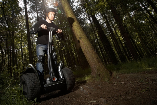 Niño con casco negro duranle su sesión en segway por el parque 