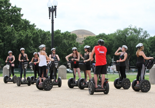  Personas vestidas de blanco Cascos preparándose para andar en segways por el parque.