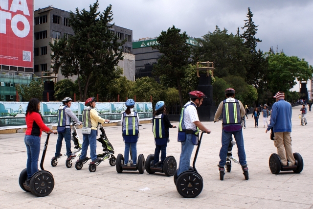  Gran grupo de personas con cascos azules y rojos duranle su experiencia en segway y yendo al parque 