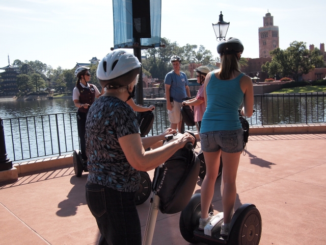  Mujes con cascos blancos y negros haciendo un recorrido en segway por el lago 