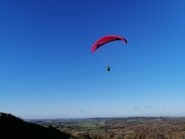  hombre volando con parapenle rojo