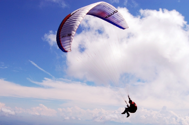  Persona volando en parapenle blanco y rojo 