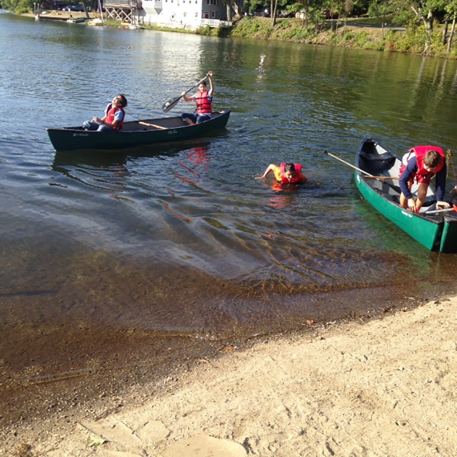 Niños y familiares preparándose para navegar en canoa por el río