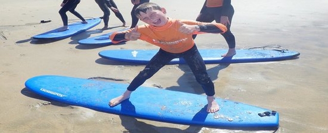  Niño feliz en su tabla de surf.