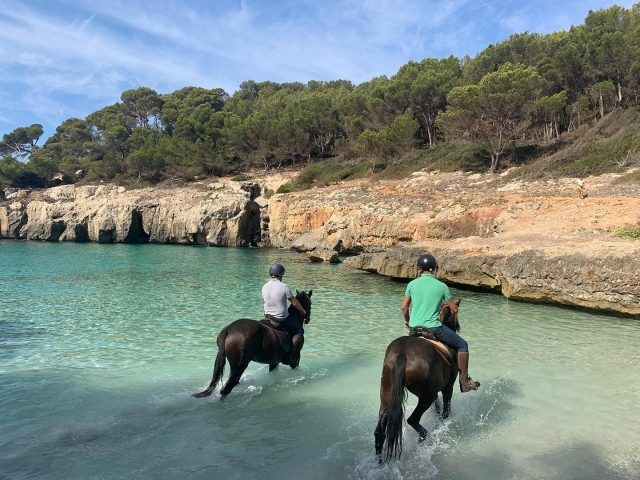 Paseando en caballo por las turquesas aguas de la Cala Fustam