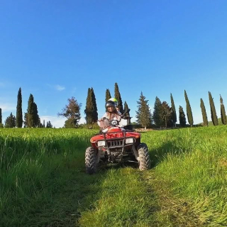  Un cuatrimoto en el prado con los cipreses 