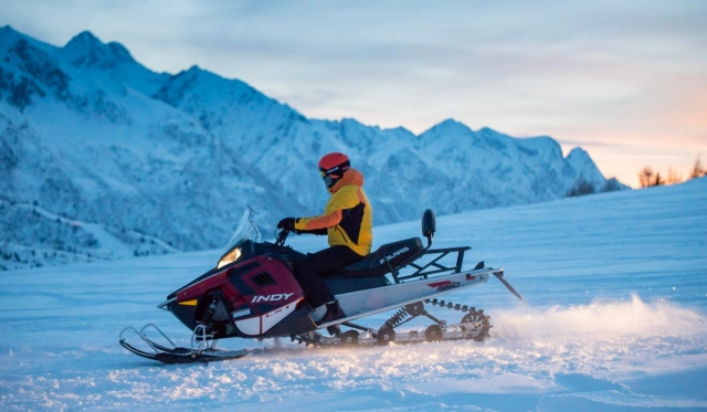  en moto de nieve al atardecer