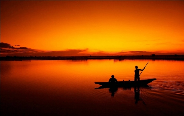  niños navegando en canoa al atardecer 